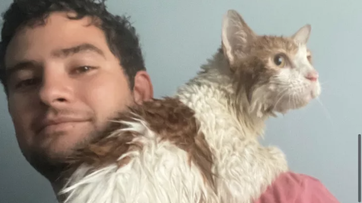 Mike Ross poses with Ian, a stray cat he rescued from Hurricane Ian in Florida.