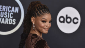 Halle Bailey smiles as she arrives at the 2021 American Music Awards.