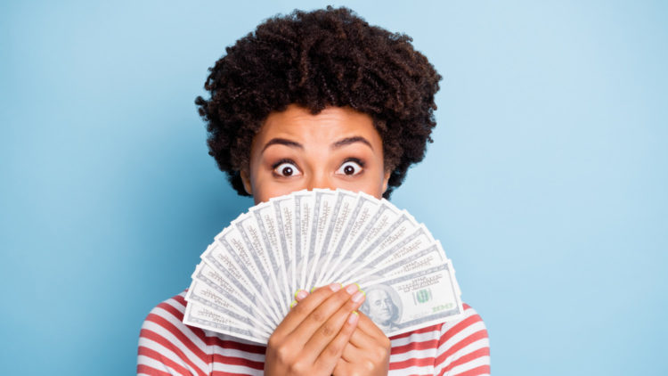 Woman holding a fan of $100 bills