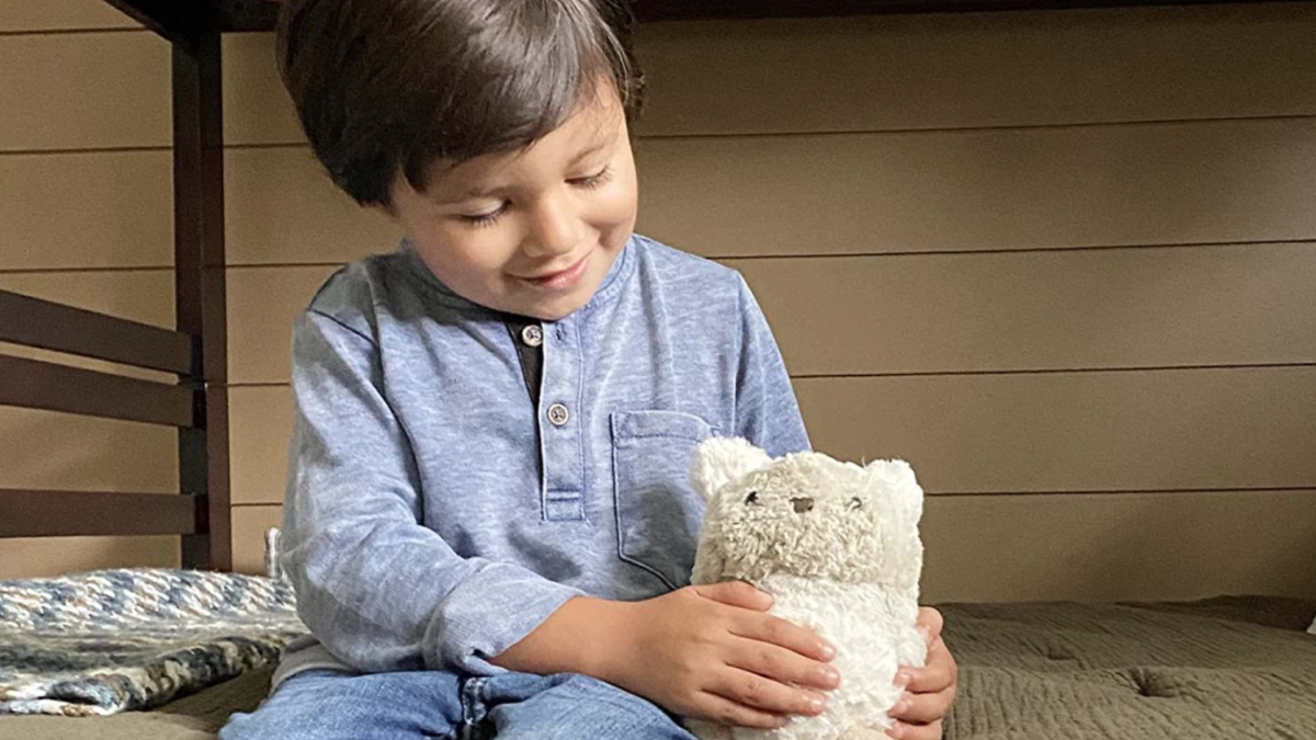 A little boy sits with a Purrble. The interactive gadget uses calming sounds and vibrations to ease anxiety.
