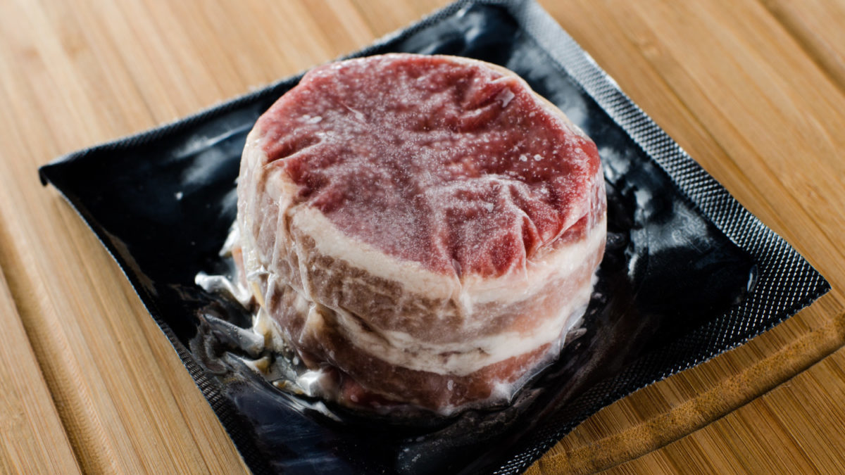 Close up photo of a vaccum sealed frozen petite steak.