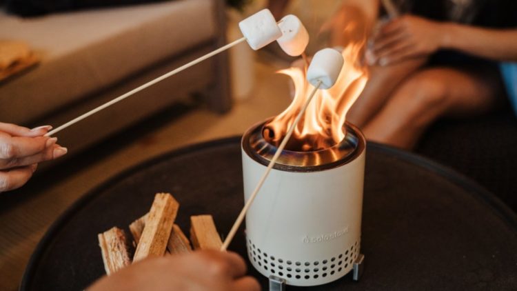 Marshmallows are roasted over the flame of a Solo Stove Mesa tabletop fire pit.