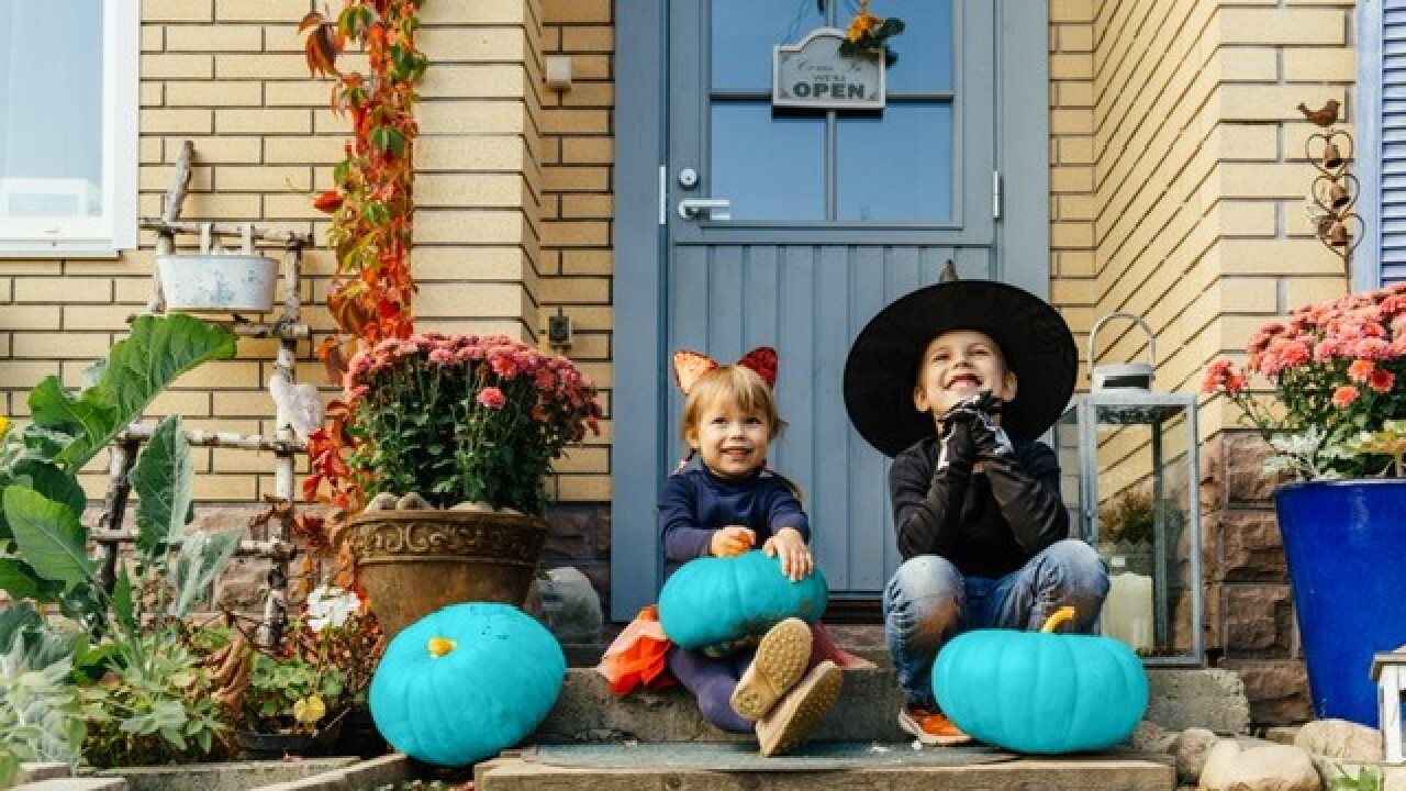 Kids with teal pumpkins on porch