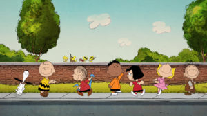 Charlie Brown, Snoopy and the Peanuts gang dance along a sidewalk.