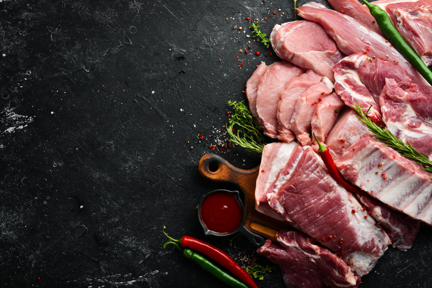 Set of raw meat. Pork meat on black stone background