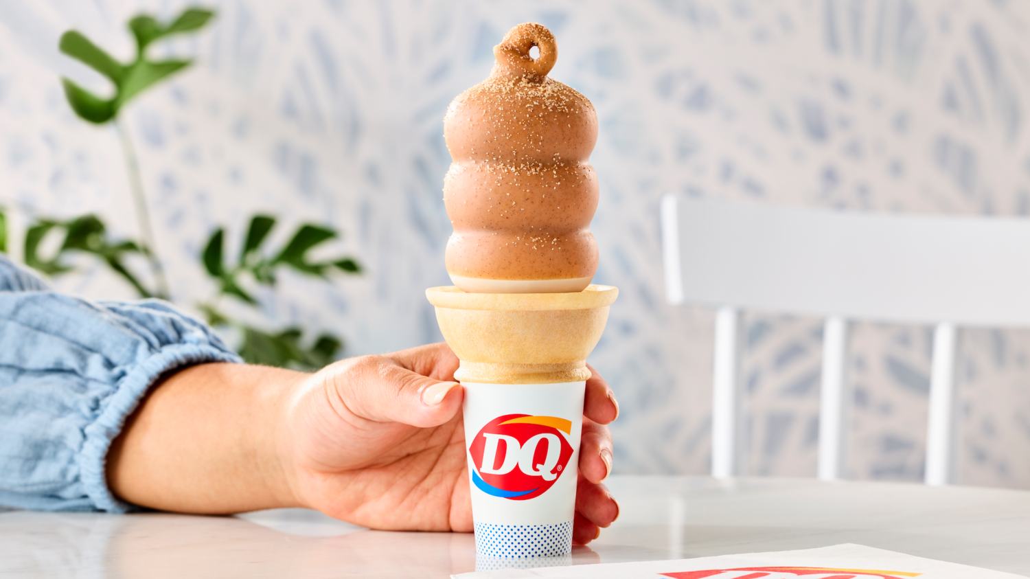 Hand holds Dairy Queen's new churro-dipped cone