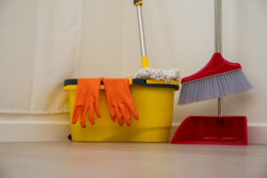 Cleaning supplies, including mop, gloves, bucket and broom