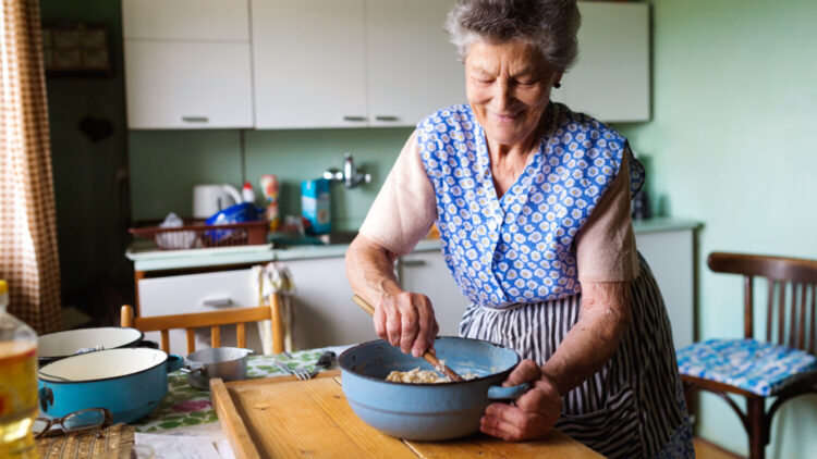 Senior woman baking pies in her home