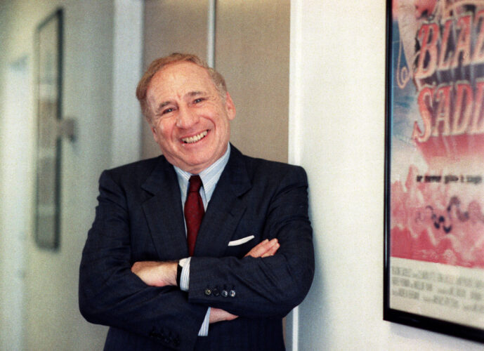 Actor-director-writer Mel Brooks poses next to a framed poster of his 1974 film "Blazing Saddles" in Los Angeles on July 23, 1991. Brooks released a memoir, "All About Me!: My Remarkable Life in Show Business."