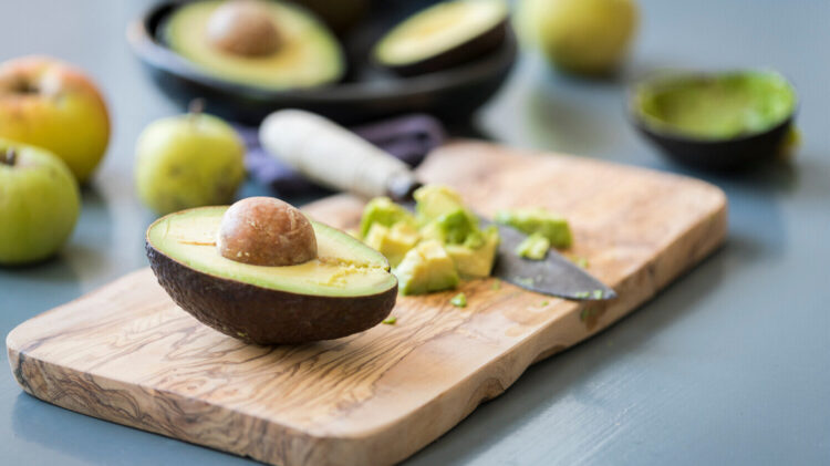 Avocado cut lengthwise on cutting board