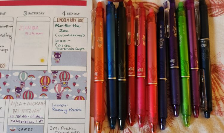 Frixion pens in multiple colors next to planner