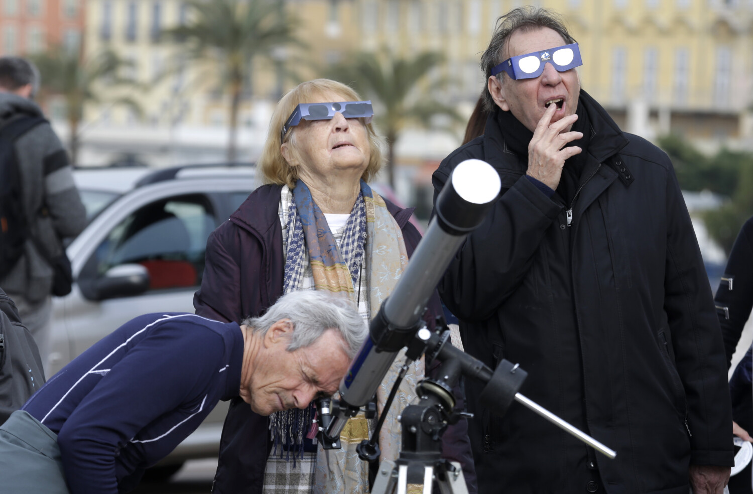 People watch solar eclipse with glasses, telescope