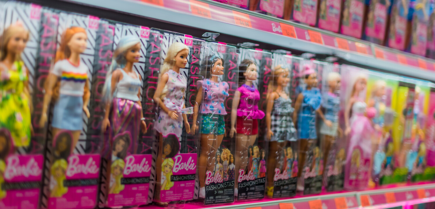 shelf full of barbie dolls in their boxes