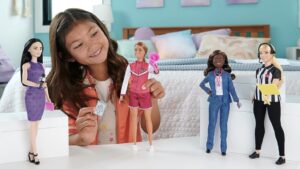 Child playing with 2023 Barbie Career of the Year dolls.