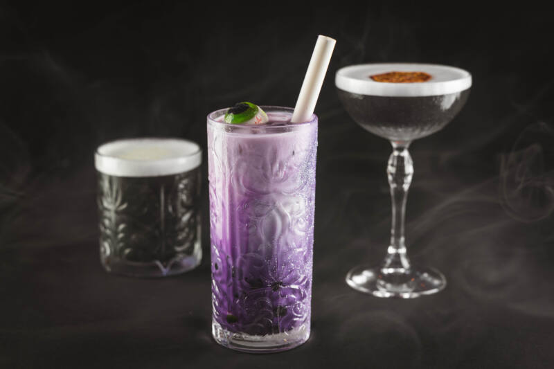 Haunted Mansion cocktails, 2 black, 1 purple with eyeball