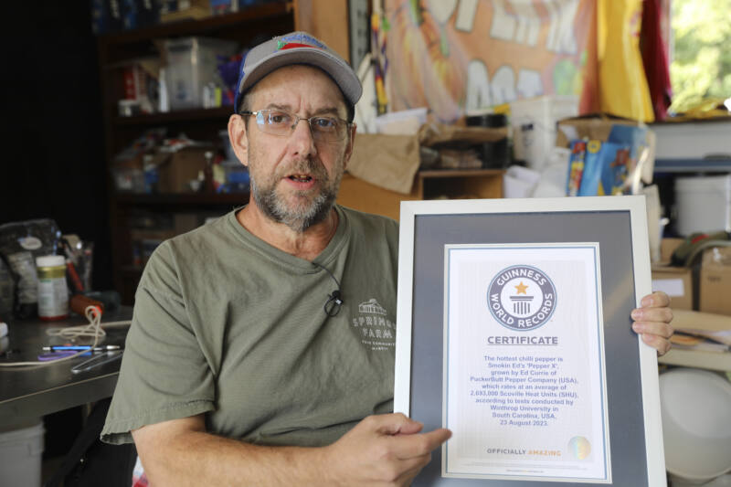 Ed Currie, cultivator of both the Carolina Reaper and Pepper X, poses with Guinness World Records plaque