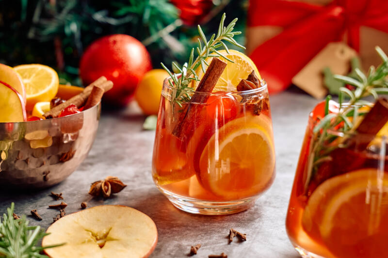 Mulled wine or Christmas cocktail with cinnamon, rosemary and orange