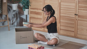 Woman boxes up belongings to donate