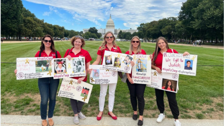 group of women holding homemade signs on national mall with U.S. capitol building in background