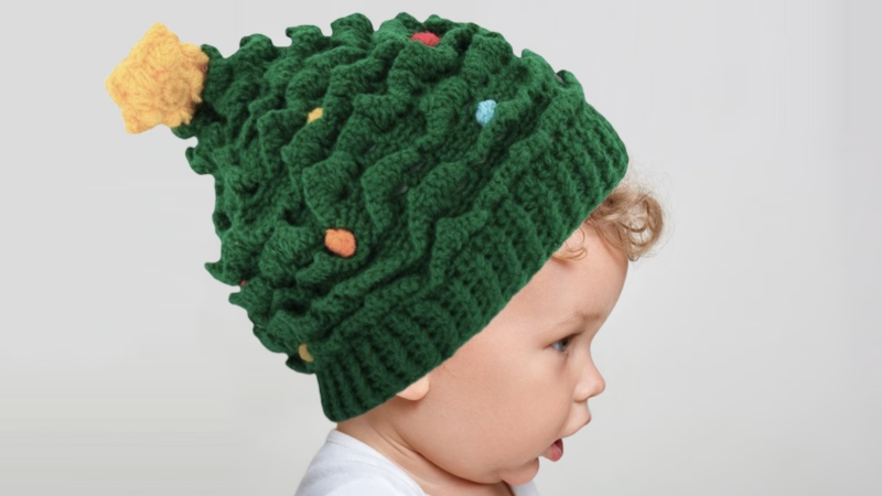 child wearing crochet christmas tree hat