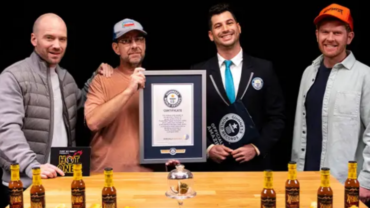 Pepper cultivator Ed Currie poses with Guinness World Records plaque alongside hosts of "Hot Ones" YouTube show and representative from Guinness