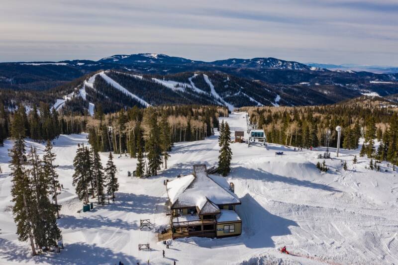 aerial view of large luxury ski cabin on snowy mountaintop 