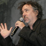 Tim Burton talking into microphone side view