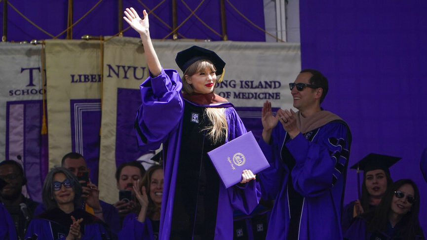 Taylor Swift, in doctoral cap and gown, waves after receiving an honorary degree during New York University’s graduation ceremony in 2022.