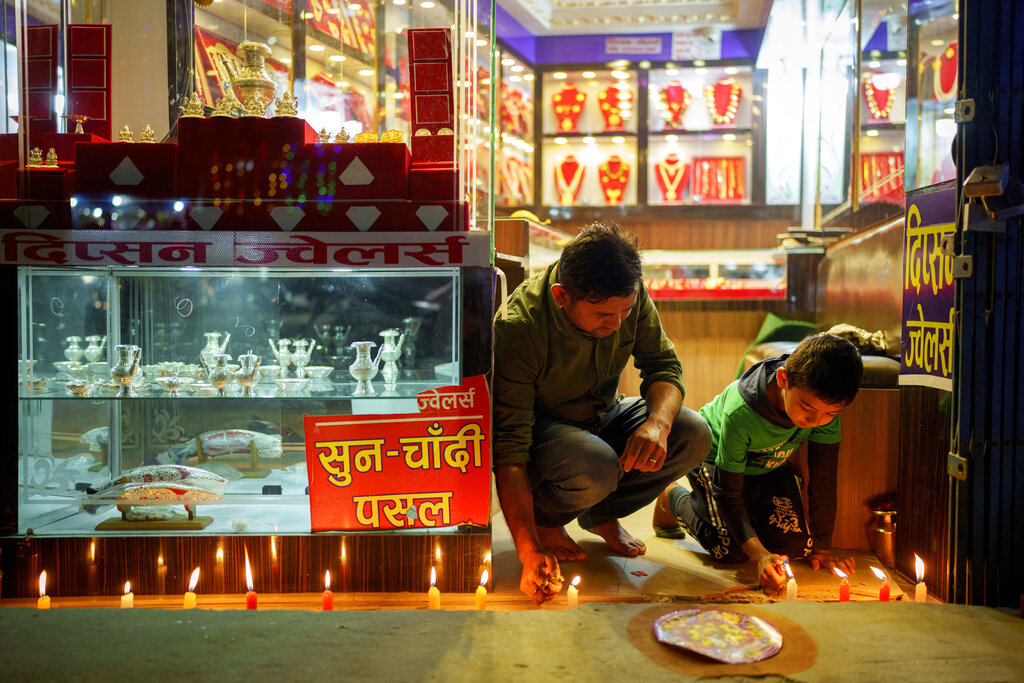 Man and child light candles for Tihar in Kathmandu