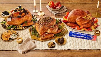 three elaborate turkey dinners on a table next to a box of reynolds wrap