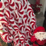 Peppermint crochet throw blanket next to Christmas tree