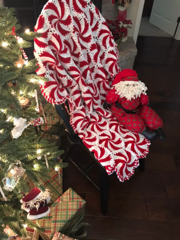 Peppermint crochet throw blanket next to Christmas tree