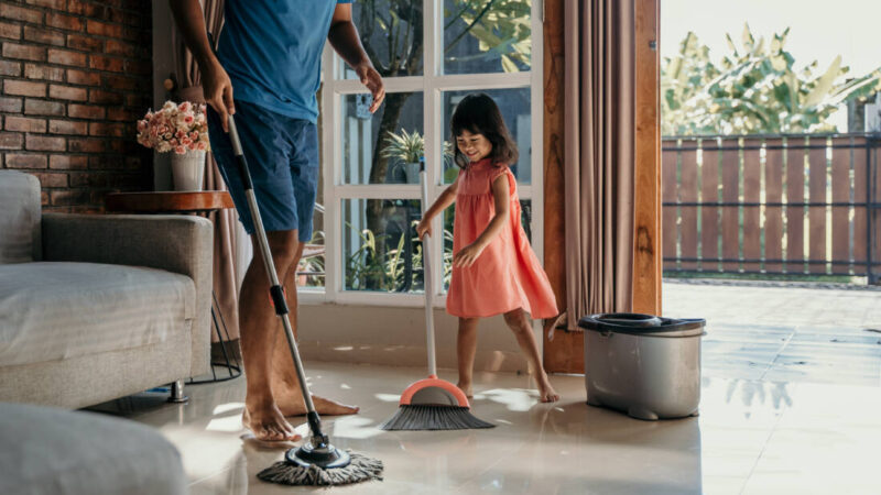 Dad and young daughter mopping the floor together