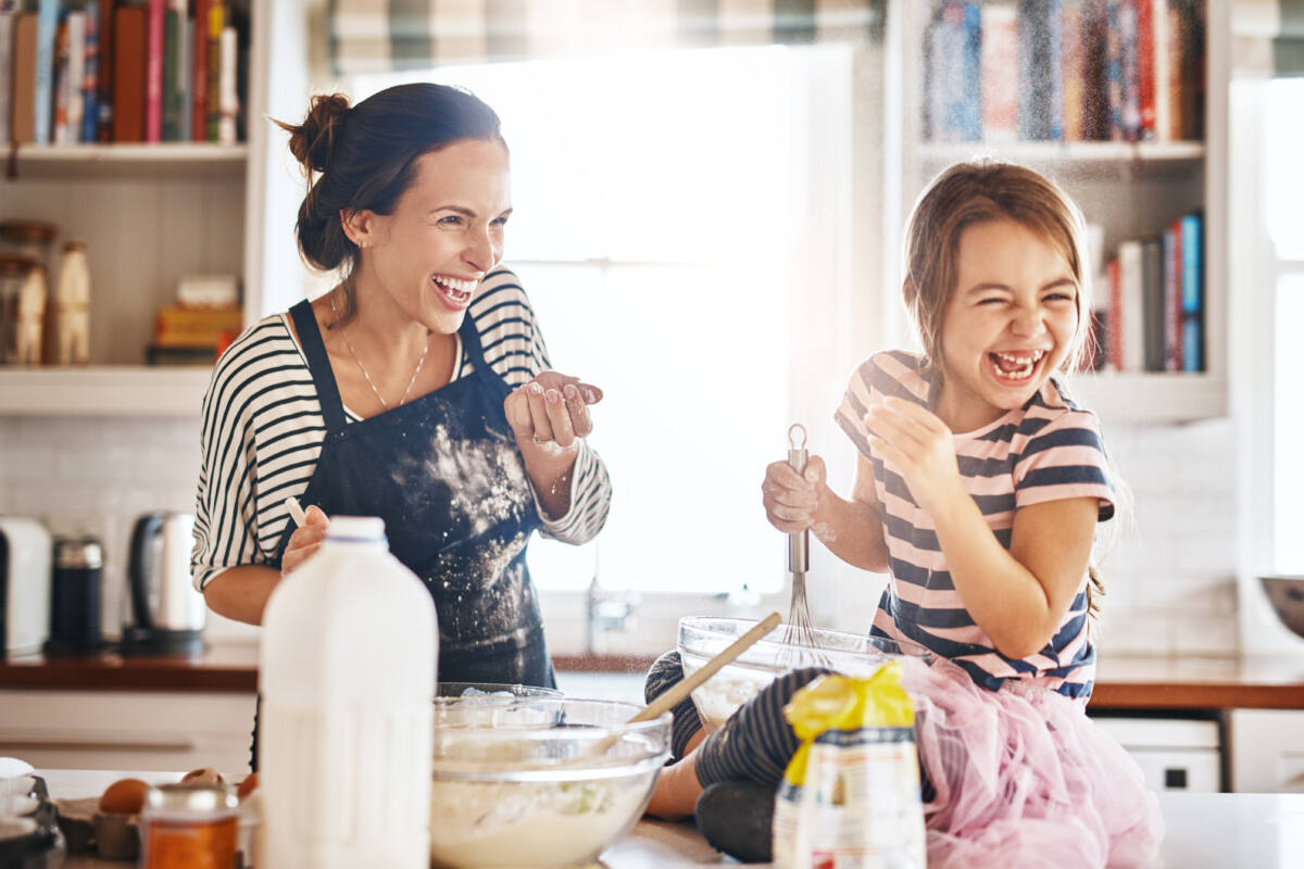 Mother, play or kid baking in kitchen as a happy family with an excited girl laughing or learning cookies recipe. Playful, flour or funny mom helping or teaching kid to bake for development at home.