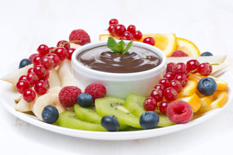 assorted fruit with chocolate sauce on a plate,