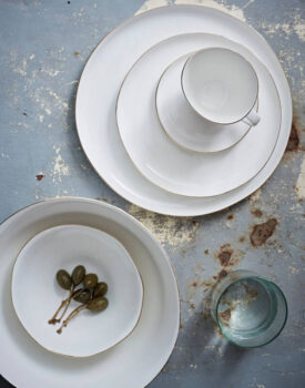 White dishes and a cup on a distressed blue tabletop