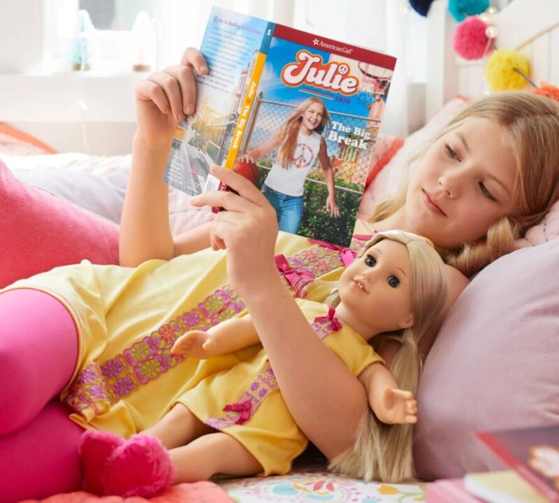 Girl reading an American Girl doll book to her American Girl Doll named Julie