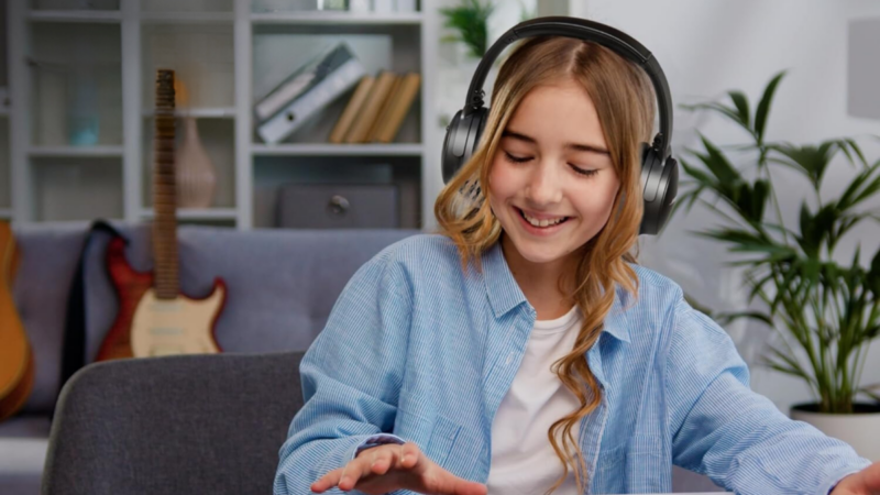 Teen girl wearing Bose noise canceling headphones while working at desk
