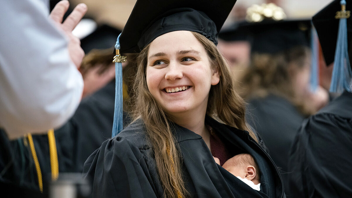 Ferris State Universit graduate Grace Szymchack tucked her 10-day-old daugher, Annabelle, into her gown and received here degree on Dec. 15.