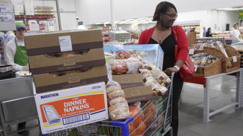 Woman shopping at Sam's Club pushes cart full of goods