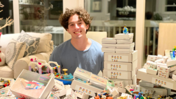 Charlie Jeffers, founder of Pass the Bricks nonprofit, poses with his original designed Lego sets from donated bricks