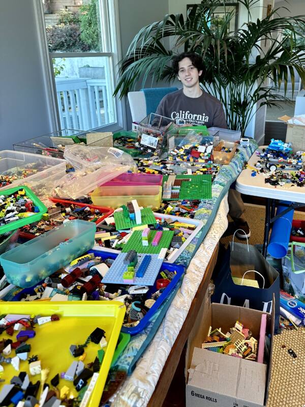 17-year-old Charlie Jeffers poses with numerous Lego sets donated to his Pass the Bricks nonprofit organization