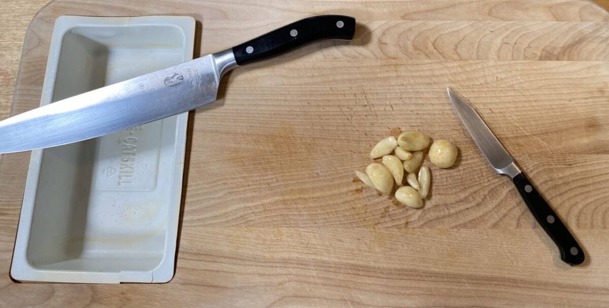 Kitchen knife and garlic cloves on counter