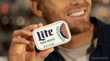 A man holding a container of Miller Lite beer mints.