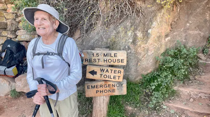 Alfredo Aliaga Burdio rests at trail sign in Grand Canyon