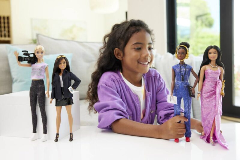 Child playing with Barbie's Career of the Year dolls.