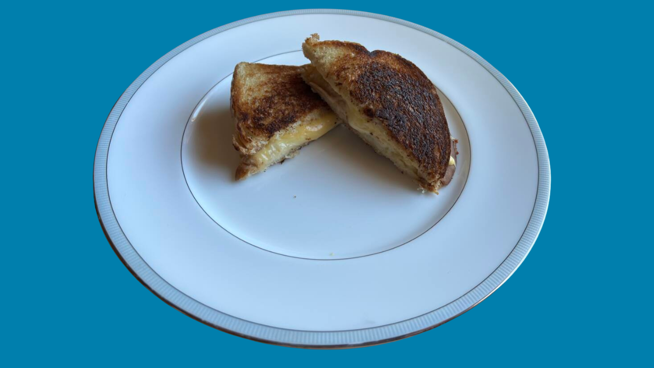 Grilled cheese sandwich cooked with bacon grease on a plate.