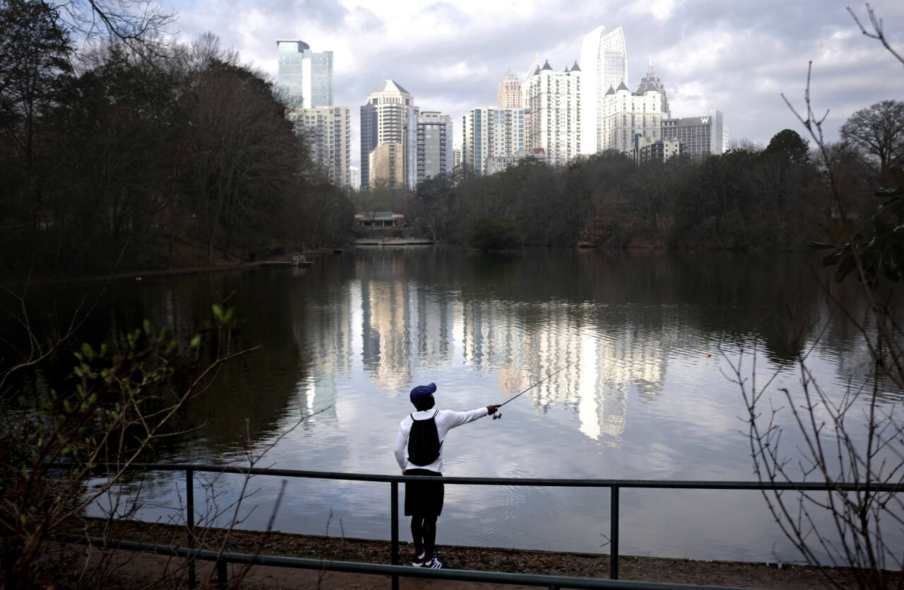 man fishing against Atlanta skyline