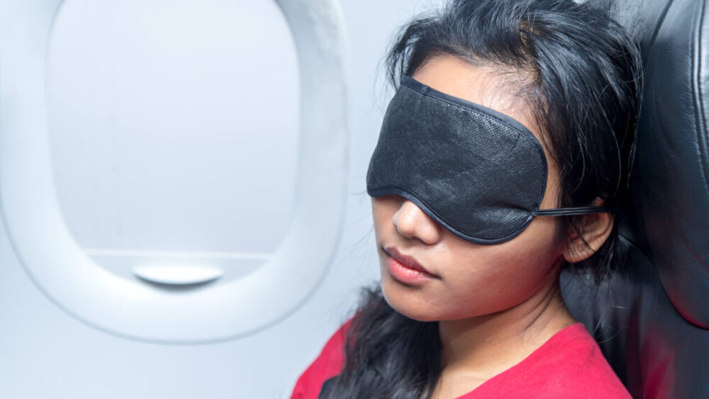 woman with eye mask sleeping on plane