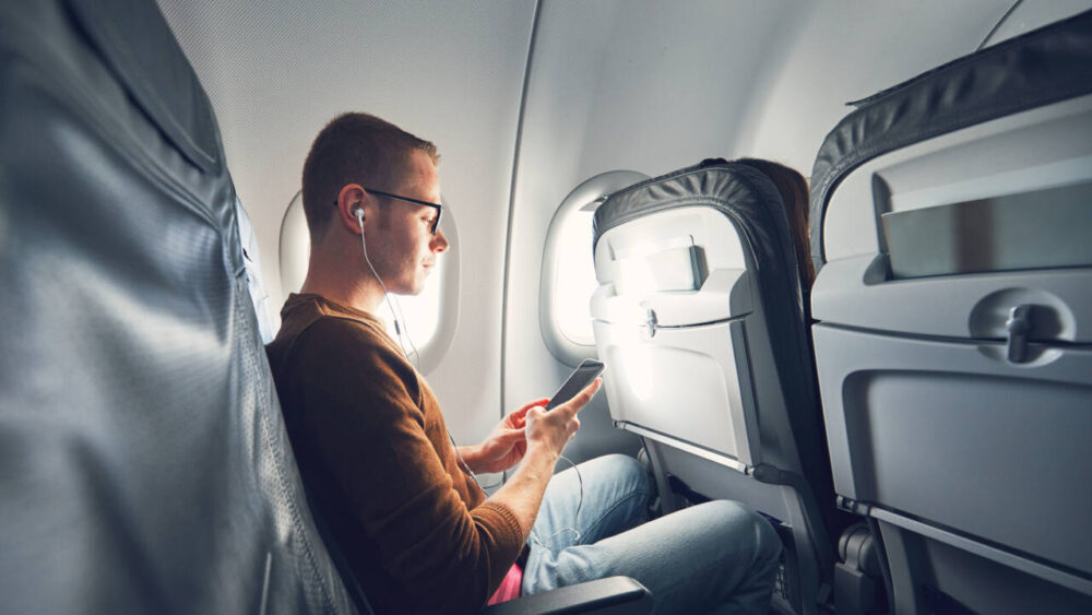 Airplane passenger wears headphones 